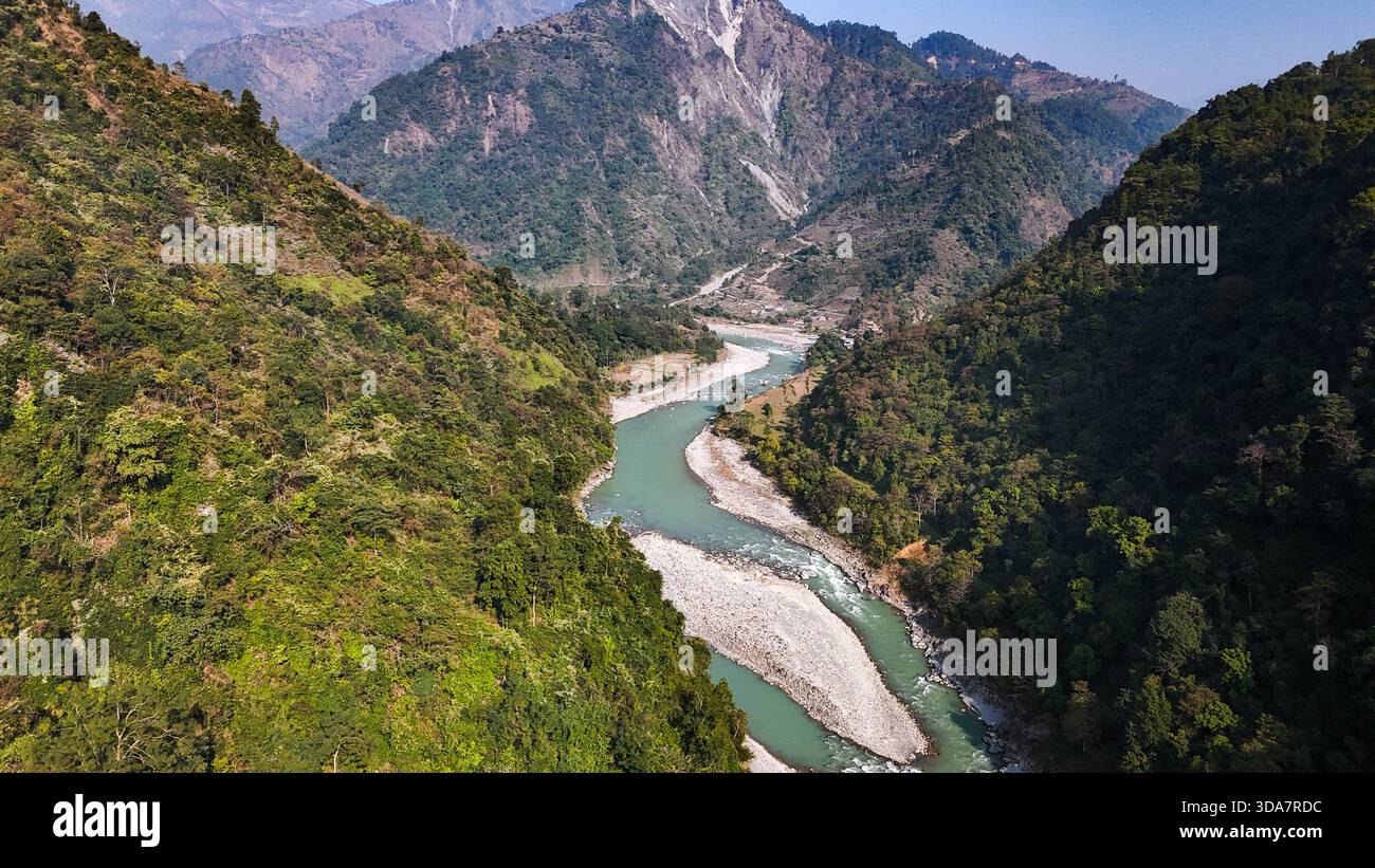 Vue aérienne de la rivière serpentine serpentant à travers la vallée accidentée le long de l'autoroute Prithvi, embrassée par les collines verdoyantes, Pokhara, Népal. Banque D'Images
