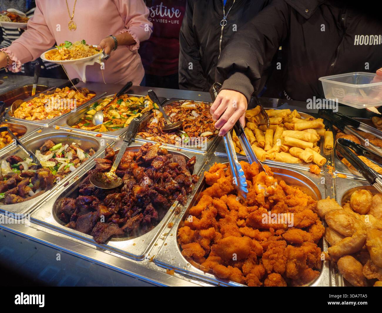 Les gens se servent à la nourriture dans un restaurant buffet chinois tout ce que vous pouvez manger à Chinatown, Londres, Royaume-Uni Banque D'Images