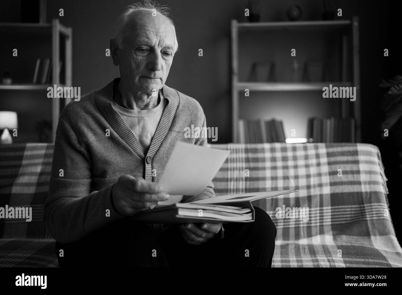 Homme senior triste avec le souvenir de chagrin sa femme. Veuf âgé seul à la maison tenant photo dans la dépression a problème de santé mentale. copier l'espace Banque D'Images