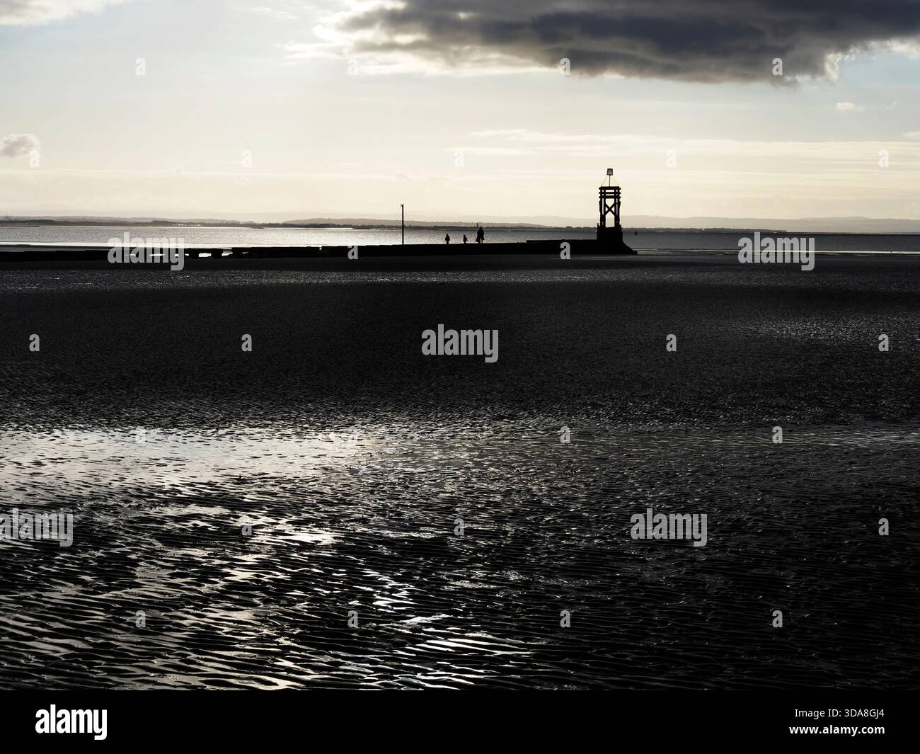 Motifs dans le sable à marée basse contre le soleil couchant sur Crosby Beach Merseyside Angleterre Banque D'Images