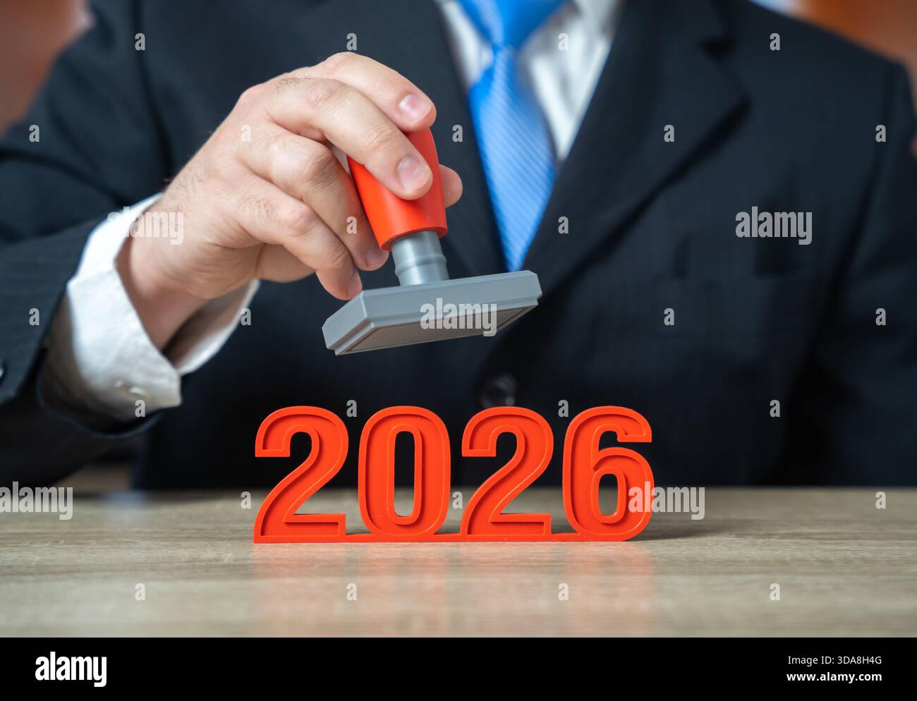 L'année 2026 et un homme d'affaires avec un timbre à la main. Rapports et fermetures avant le début de la nouvelle année. Délais financiers, dépôts réglementaires. Banque D'Images