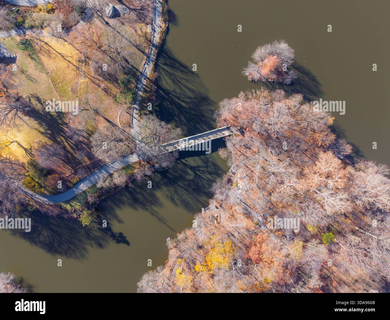 Vue aérienne d'un pont en bois reliant les îles avec le feuillage d'automne projetant de longues ombres sur l'eau, Manhattan, New York, États-Unis. Banque D'Images