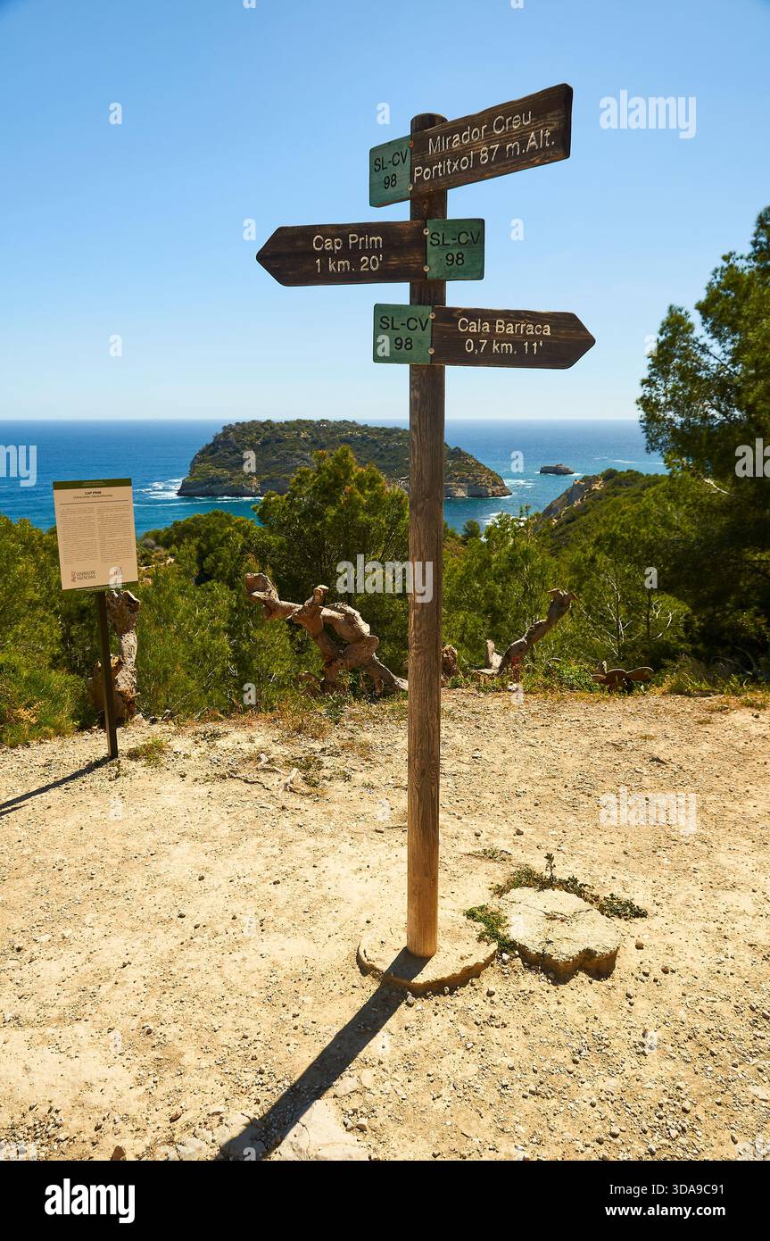 Panneau indiquant les randonnées Cala Barraca et Cap Prim, avec Isla del Portitxol en arrière-plan (Portichol, Jávea, Marina Alta, Alicante, Espagne) Banque D'Images
