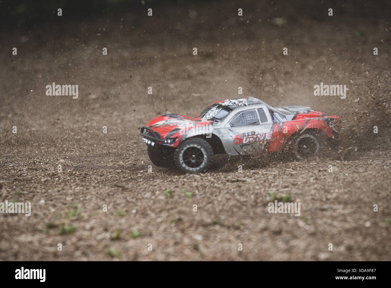 Tombereau tout-terrain RC à grande vitesse dégageant de la saleté lors d'une dérive Banque D'Images