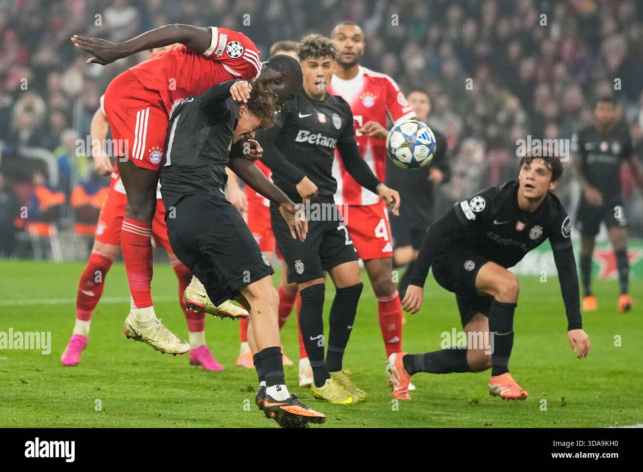 Bayern's Dayot Upamecano, left, heads the ball ahead of Sporting's Ricardo Mangas during the Champions League opening phase soccer match between FC Bayern Munich and Sporting CP in Munich, Germany, Tuesday, Dec. 9, 2025. (AP Photo/Matthias Schrader) Banque D'Images