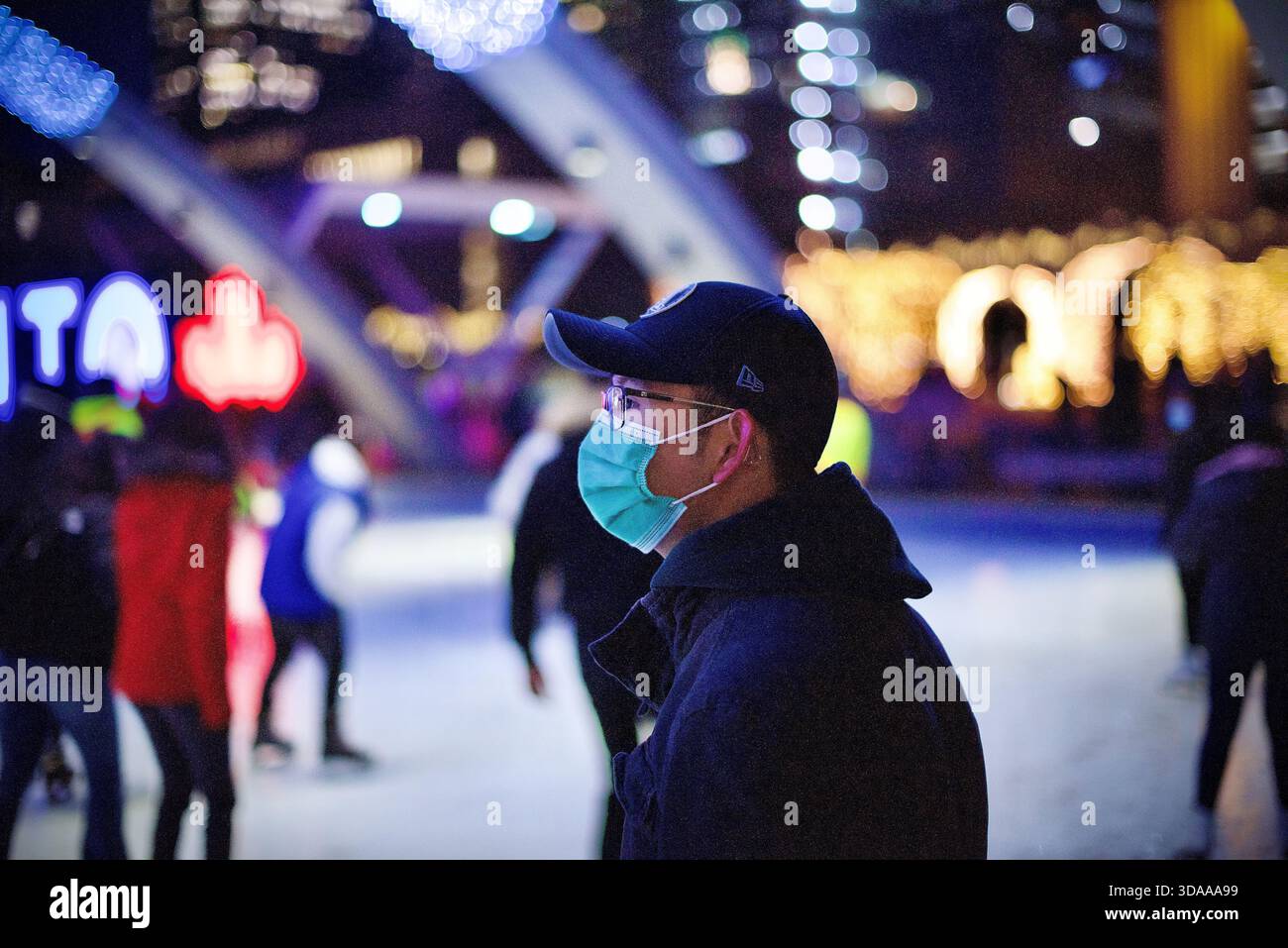 Photo de la tête d'un homme portant des masques alors qu'il patinait sur la glace au Nathan Philip Square de l'hôtel de ville de Toronto Banque D'Images