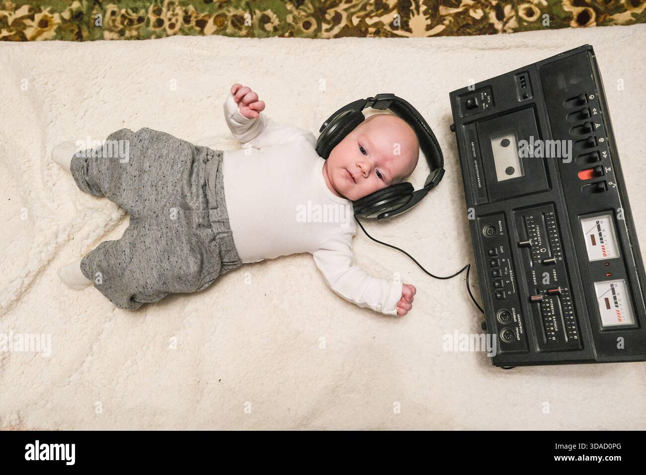 Biélorussie, Misk, 23.01.2023 bébé avec écouteurs et magnétoscope. L'écoute musicale du nourrisson pour le développement de la petite enfance. Divertissement pour enfants c Banque D'Images