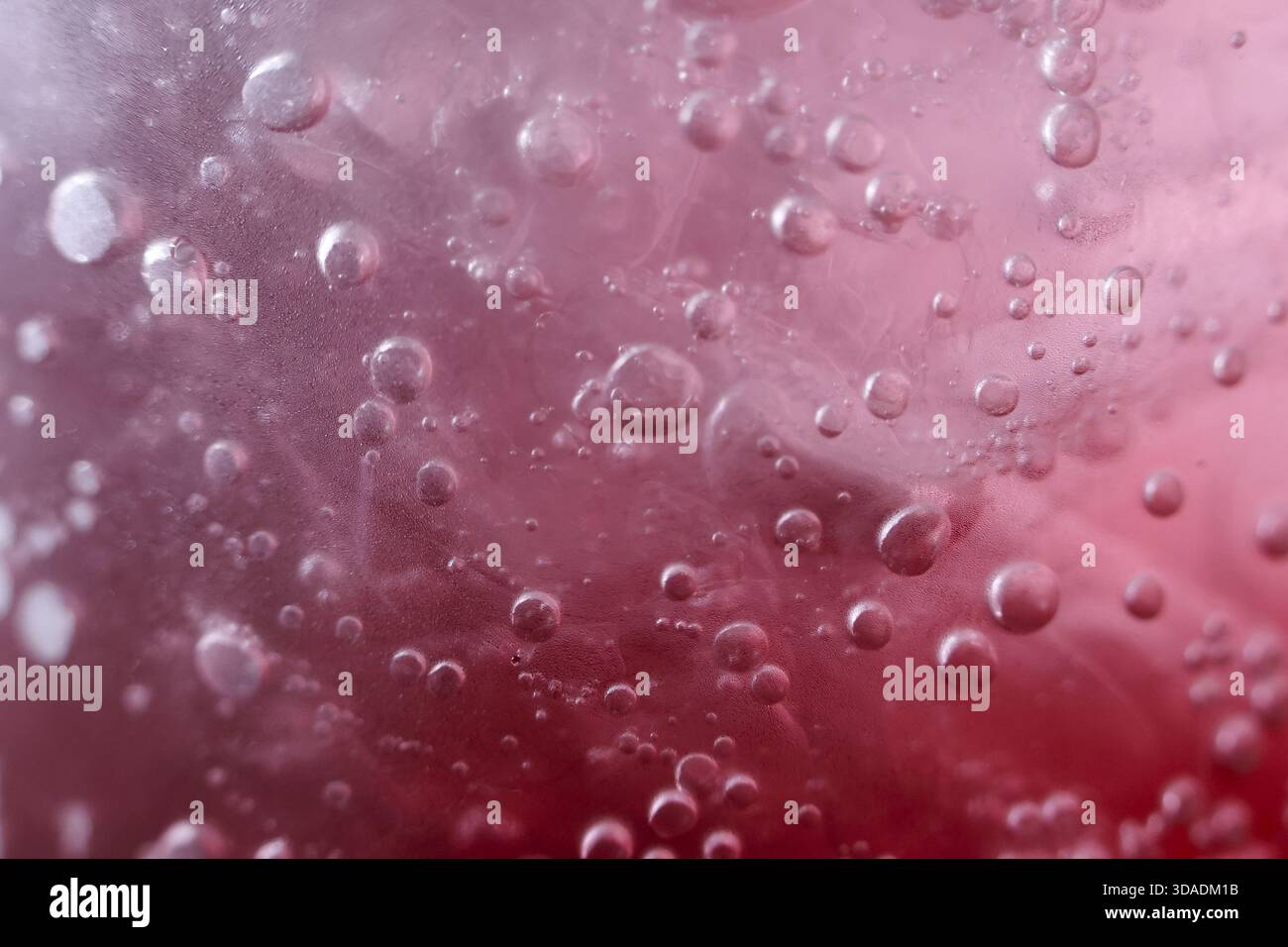 Macro fond abstrait de liquide pétillant rouge avec de la soude gazeuse rafraîchissante. gros plan vue détaillée de l'eau pétillante avec une texture énergique et beaucoup Banque D'Images