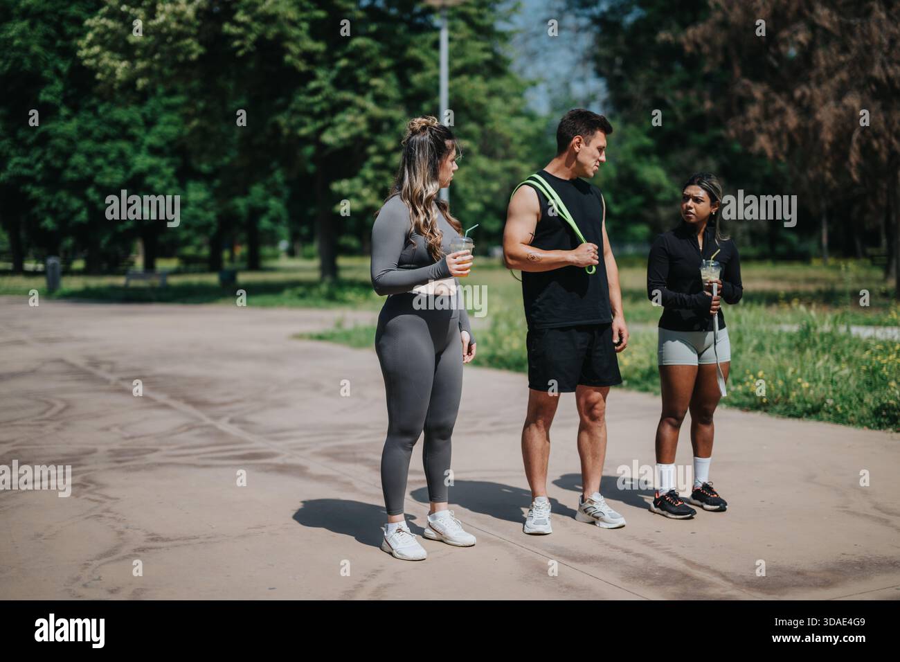 Groupe d'amis en tenue active se reposant après un entraînement de fitness en plein air Banque D'Images