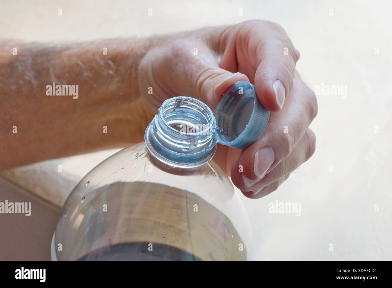 Bouchon en plastique à vis fixé sur une bouteille PET. Conformément à la réglementation du parlement européen, le bouchon reste attaché au flacon après ouverture. Protection de l'environnement Banque D'Images