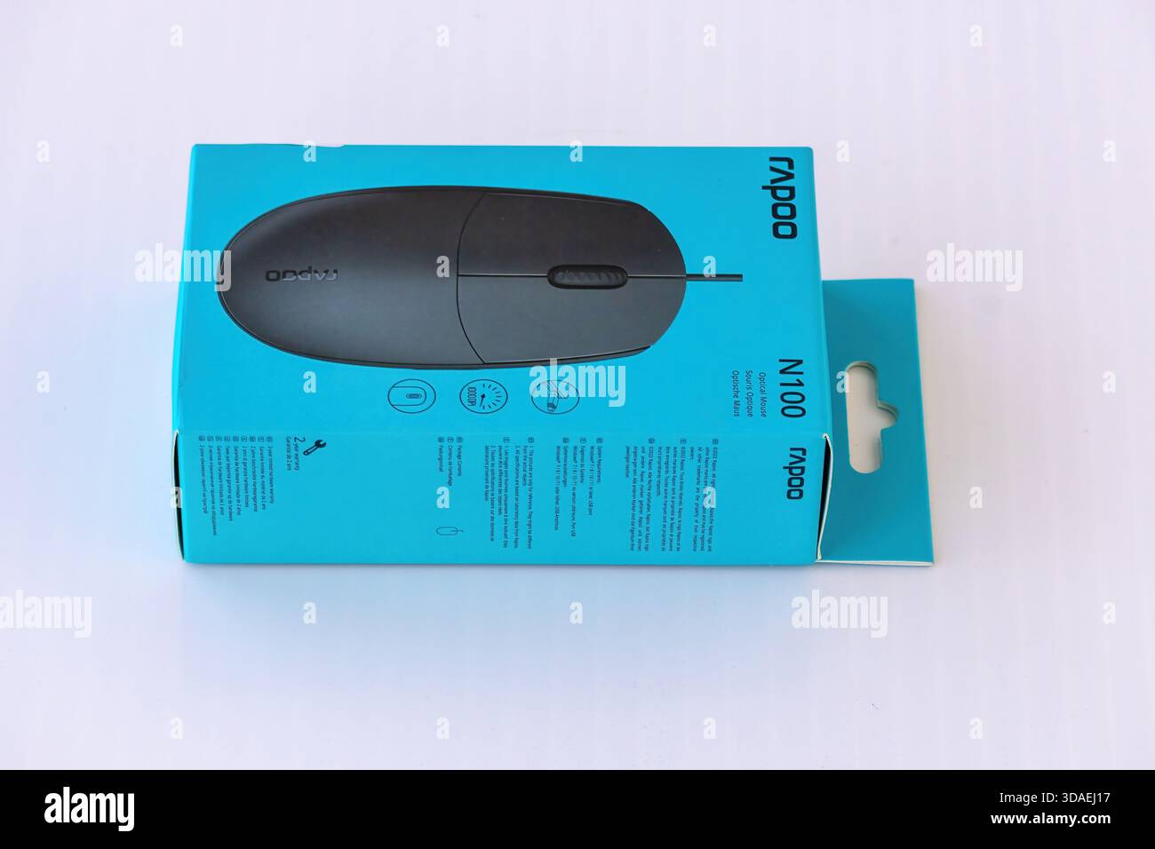 Gros plan d'une nouvelle souris optique filaire Rapoo N100 présentée dans son emballage d'origine, non ouvert, mettant en évidence le nom du produit, le numéro de modèle et i. Banque D'Images
