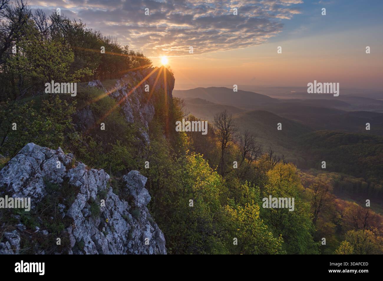 Vue aérienne de l'éclat radieux du soleil sur le rocher Cierna Skala, au milieu du paysage luxuriant, créant un contraste étonnant de lumière et d'ombre, Plavecky M. Banque D'Images