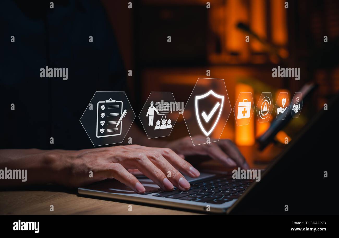 Concept de sécurité et de conformité au travail. Personne tapant sur ordinateur portable avec des icônes sécurité au travail, conformité, gestion des risques, efficacité opérationnelle, santé Banque D'Images