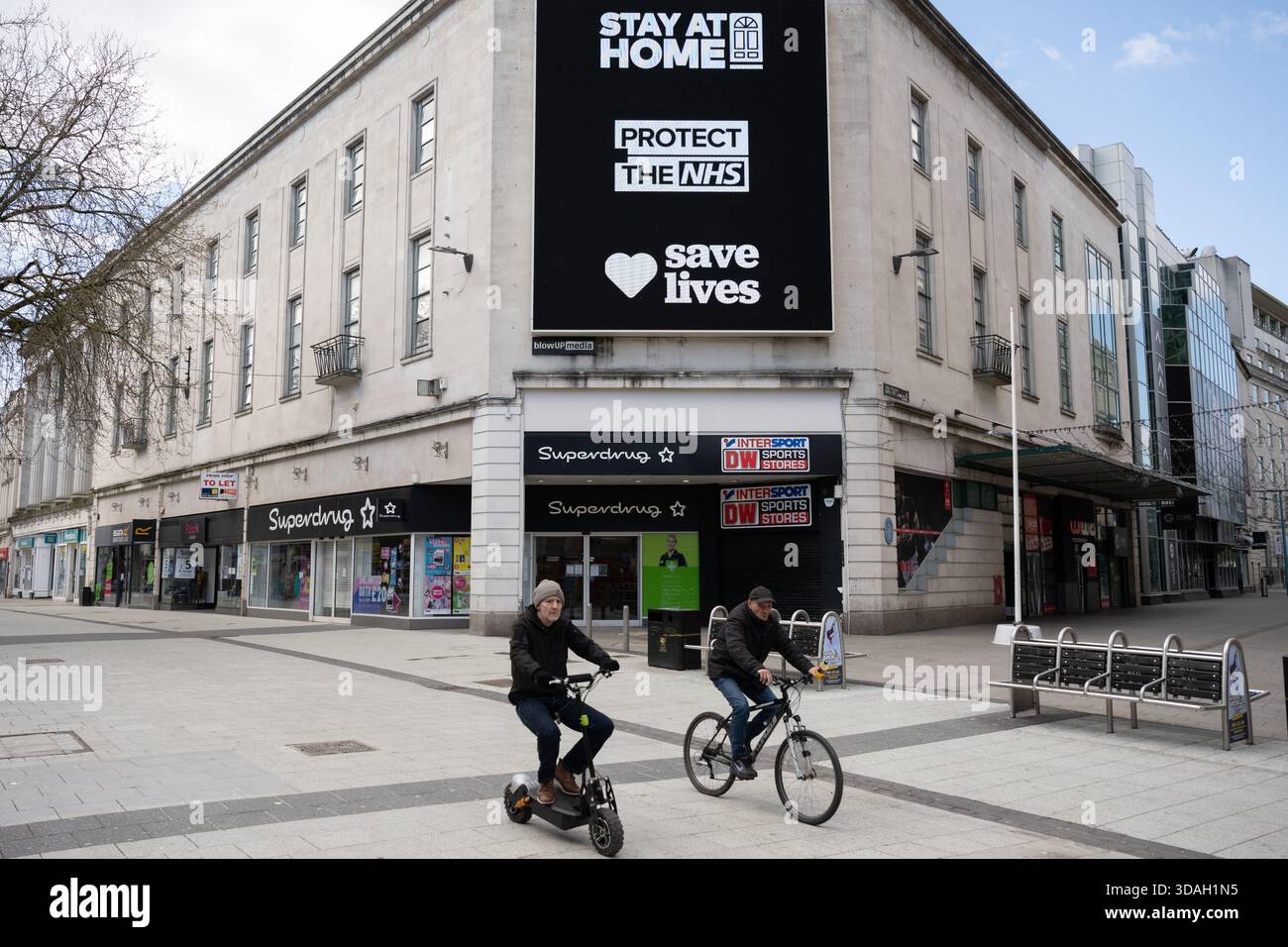 Un grand panneau d'affichage noir affiche bien en évidence le message « RESTEZ À LA MAISON » au-dessus de « PROTÉGEZ LE NHS » et « SAUVEZ DES VIES » avec un symbole de cœur entre les deux sur le Qué Banque D'Images