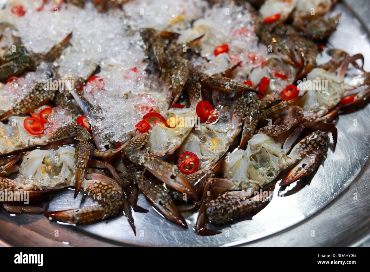 Appétissant plat de crabe cru préparé avec du piment rouge épicé sur de la glace pilée. Délicatesse de fruits de mer frais de la cuisine thaïlandaise, cuisine traditionnelle et authentique ex Banque D'Images