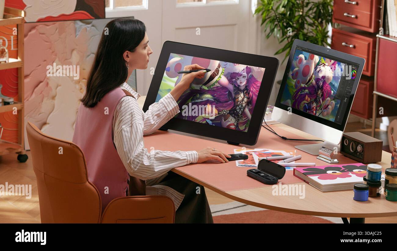 Artiste numérique féminin dessinant un personnage animé coloré sur tablette graphique dans un studio à la maison lumineux Banque D'Images