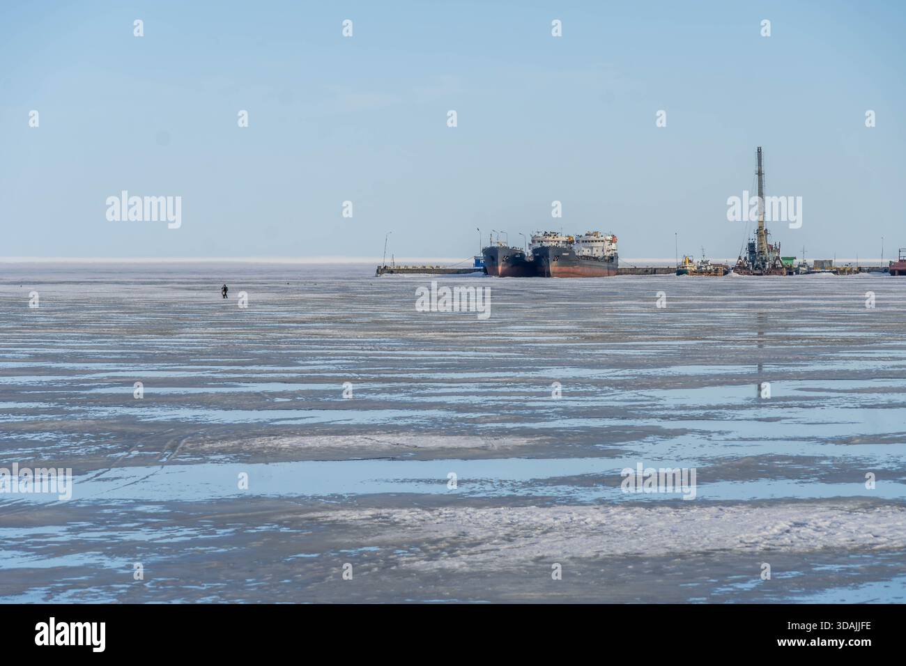Les cargos et la grue de dragage sont amarrés au port industriel de Petrozavodsk sur le lac gelé Onega, mettant en évidence l'infrastructure portuaire du nord. Banque D'Images
