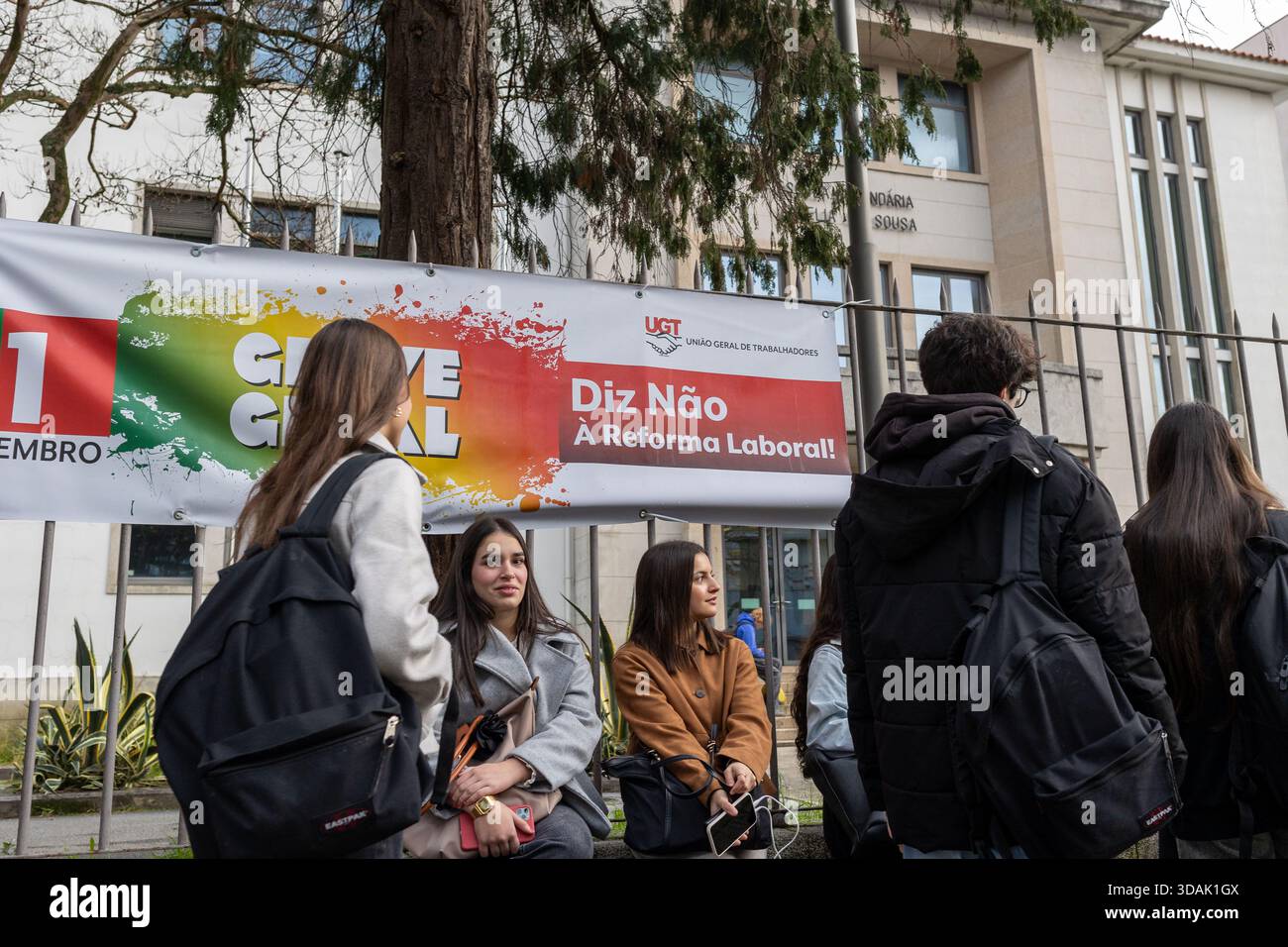 Les étudiants se rassemblent devant Escola Secundária Aurélia de Sousa à Porto le 11 décembre 2025, alors que les cours sont suspendus pendant la grève générale nationale, avec des banderoles de protestation affichées à l'entrée. Banque D'Images