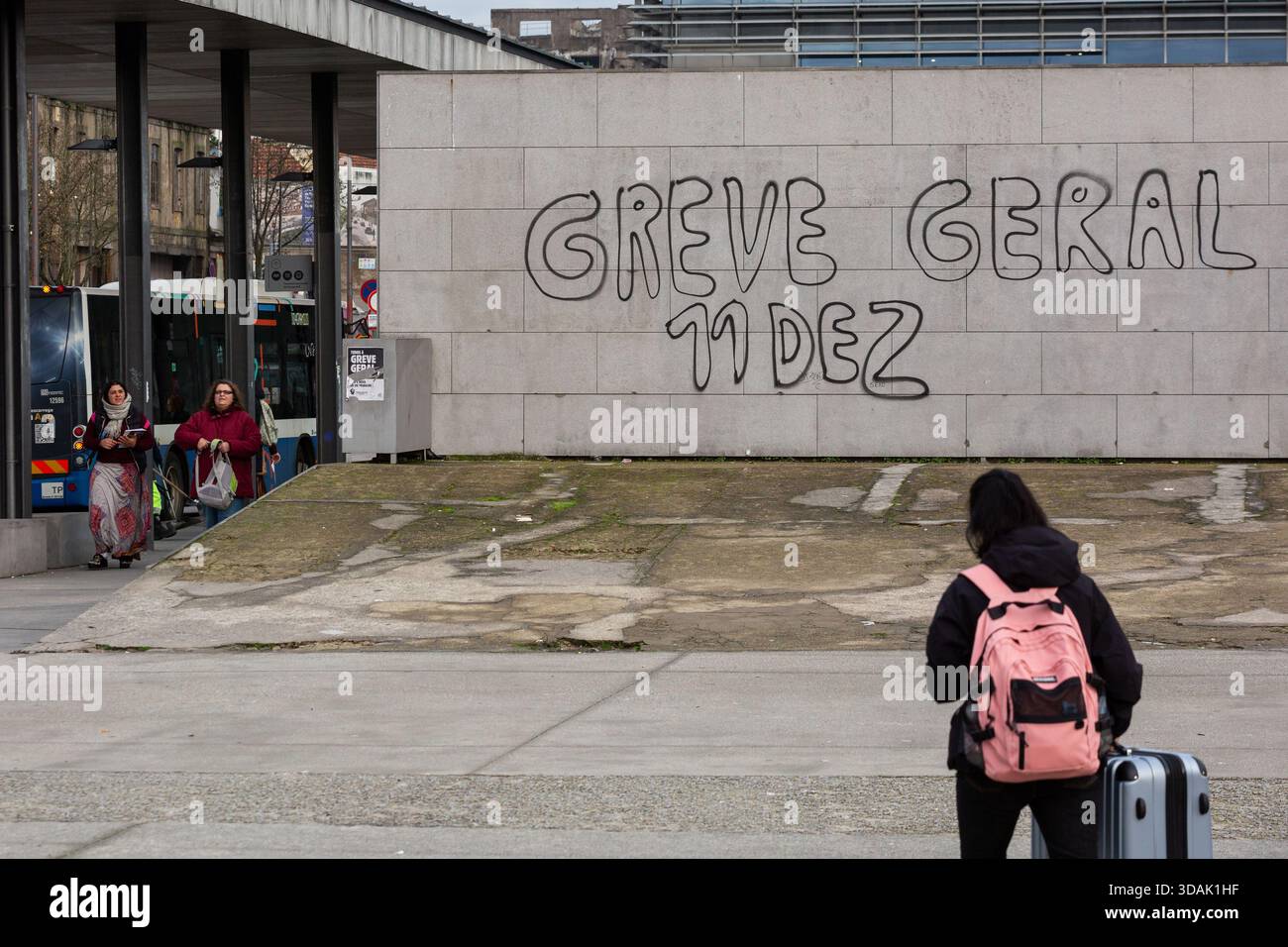 Une personne passe devant un graffiti lisant « GREVE GERAL 11 DEZ » près d'un arrêt de bus à Porto le 11 décembre 2025, car les transports publics sont perturbés pendant la grève générale nationale. Banque D'Images