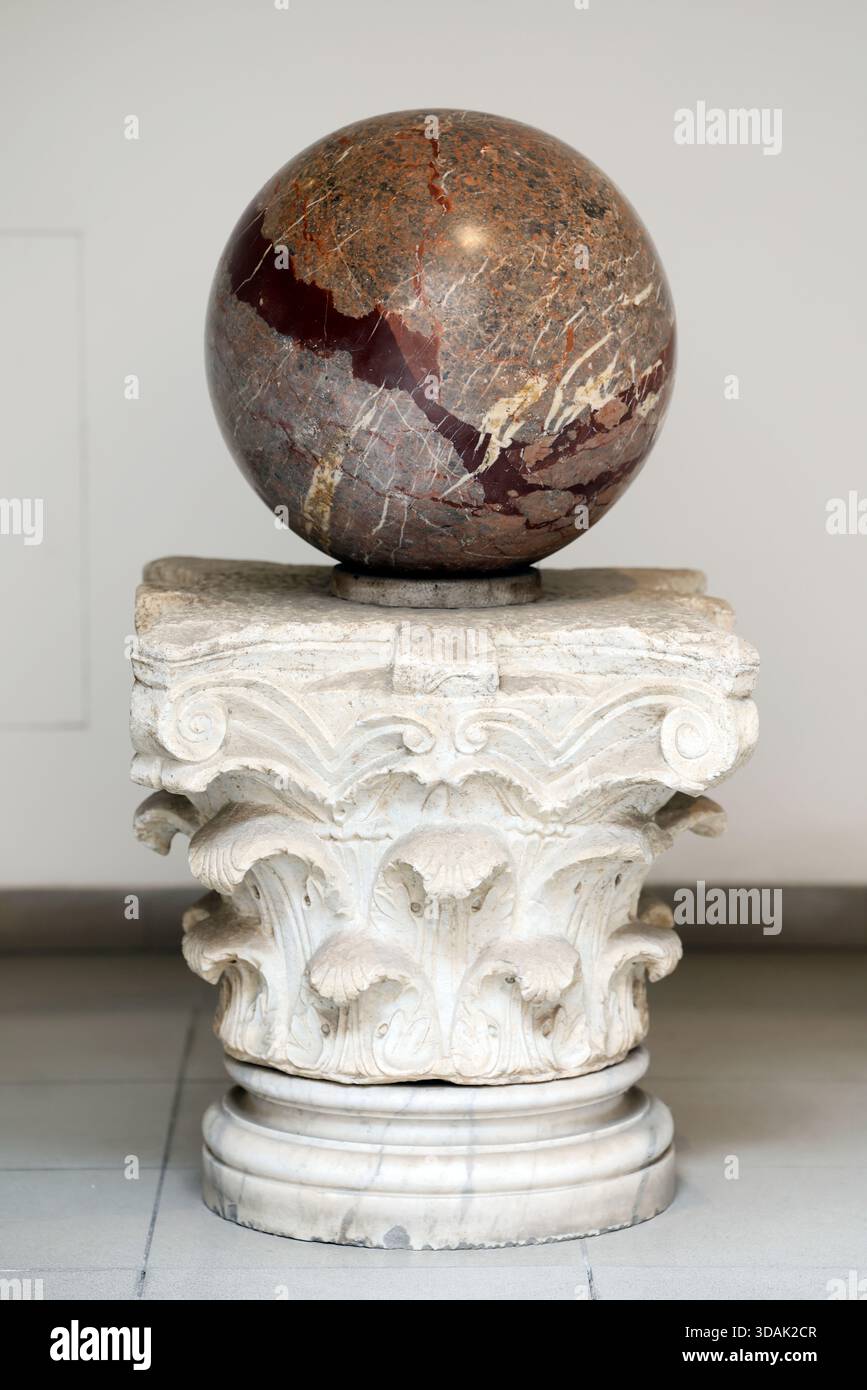 Musées du Capitole. Fragment du colosse de Constantin : orbe de marbre poli exposé sur une ancienne capitale corinthienne, évoquant l’empereur Banque D'Images