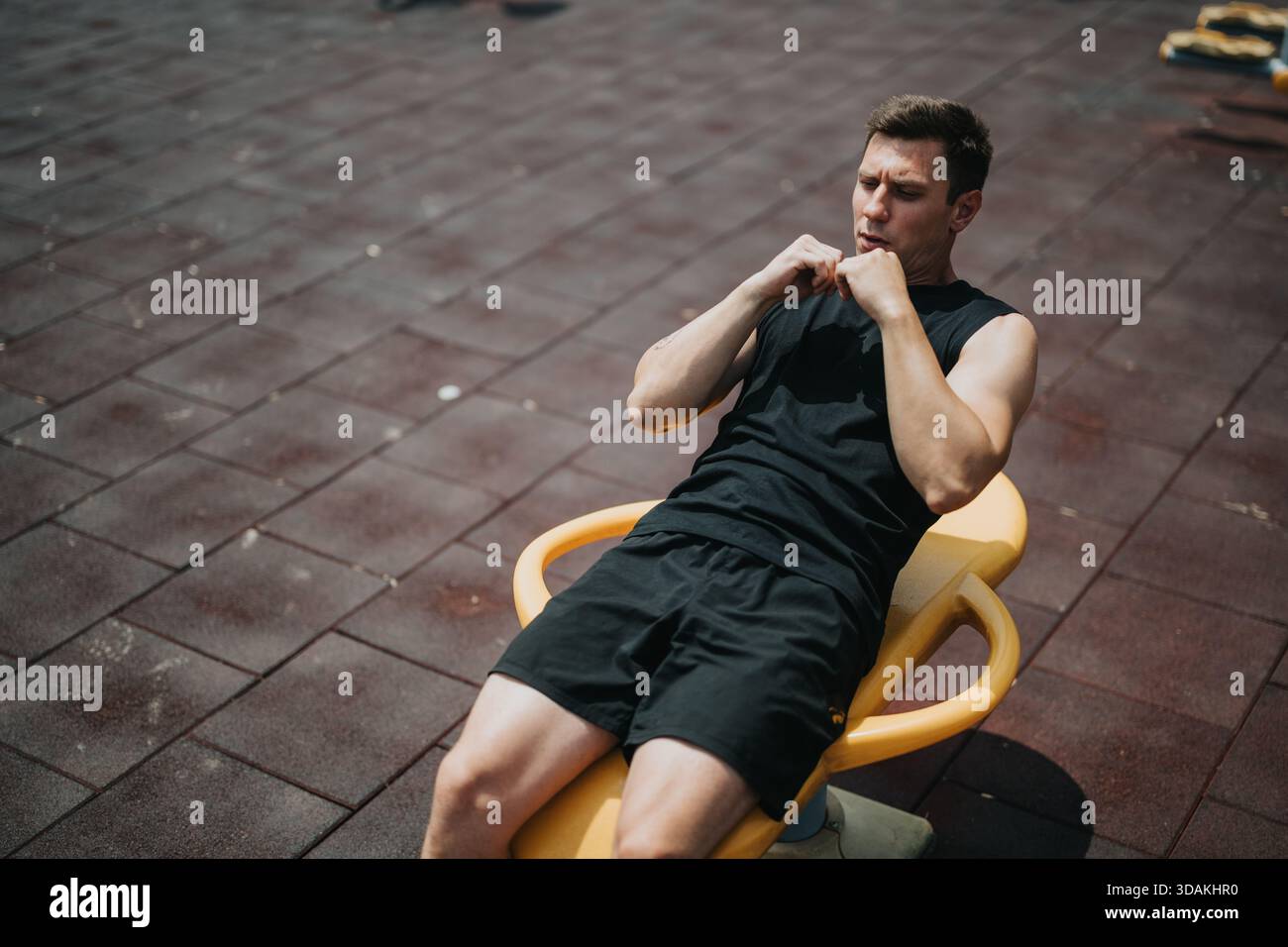Homme effectuant des sit-ups à l'extérieur sur un banc d'entraînement dans le gymnase Banque D'Images