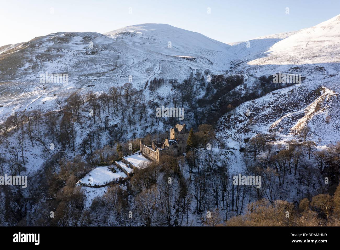 Vue aérienne du château Campbell niché au milieu d'un pays des merveilles hivernales, ses pierres anciennes contrastent avec les collines immaculées couvertes de neige, Dollar, Scotla Banque D'Images