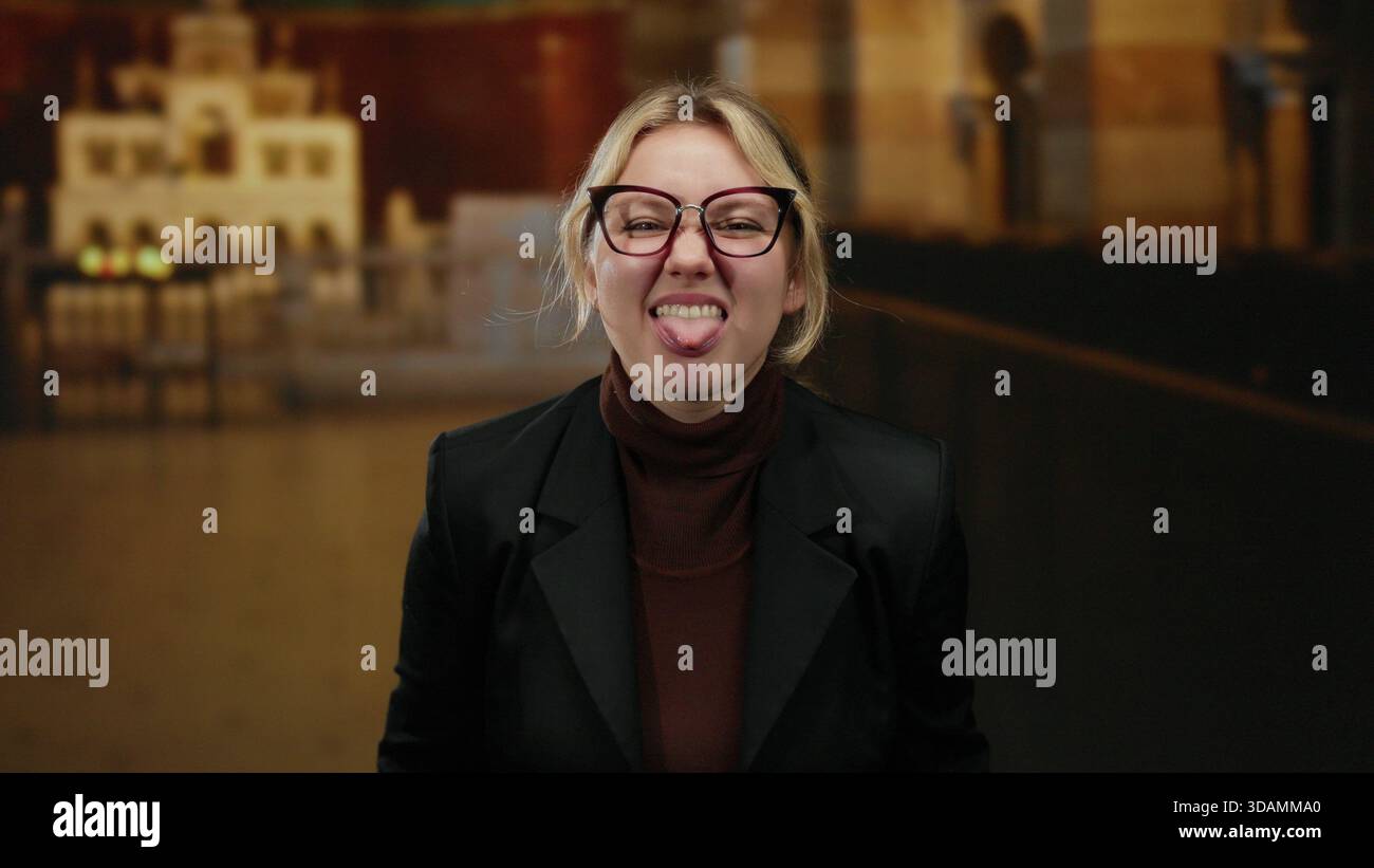 Femme souriant à l'intérieur avec des lunettes dans un cadre d'église, affichant une joie ludique et la légèreté, incarnant jeune, blonde, énergie caucasienne et cha Banque D'Images