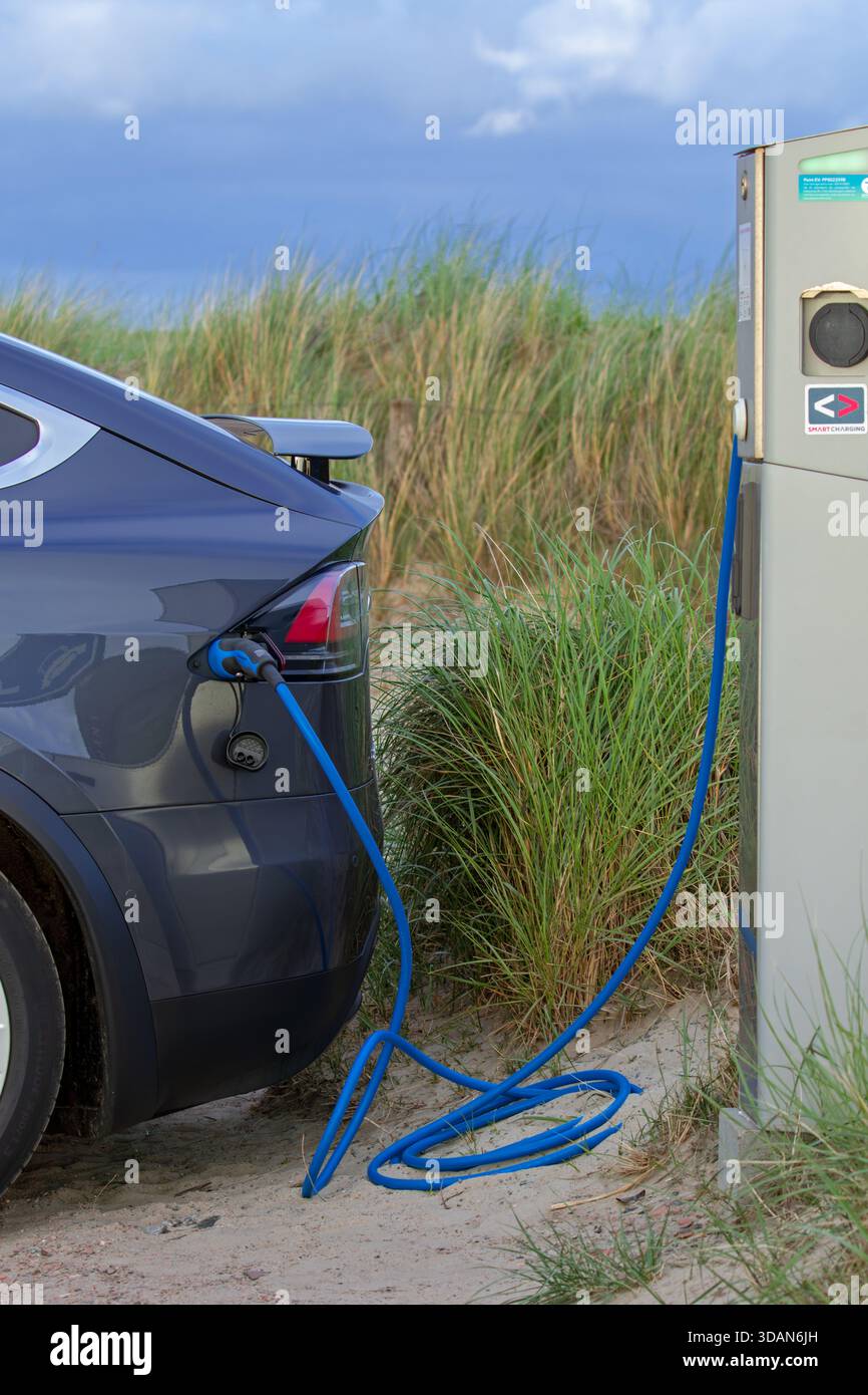 Recharge de véhicule électrique / VE à la borne de recharge publique / point de chargement pour voitures électriques dans les dunes de l'île Texel, pays-Bas Banque D'Images