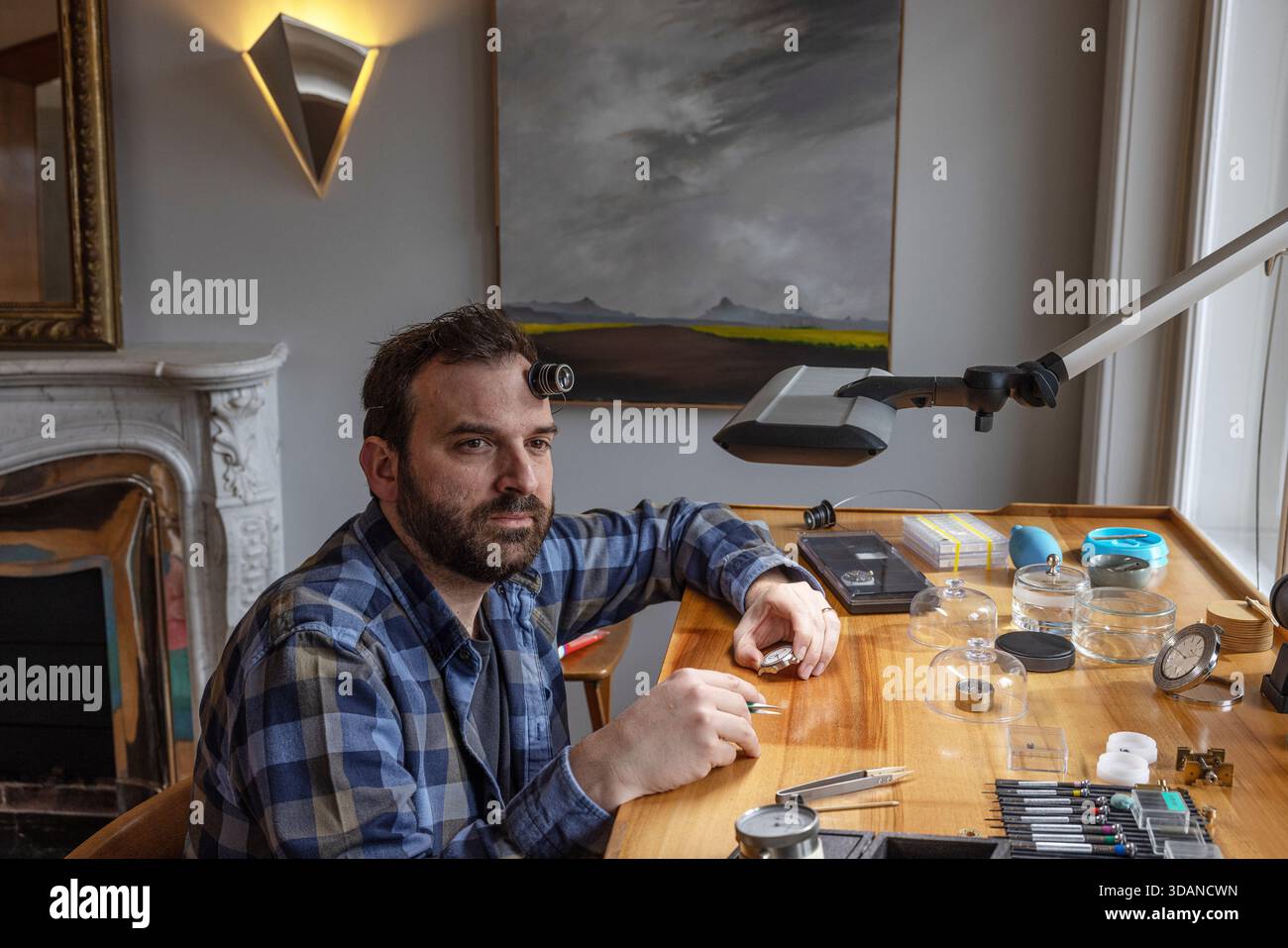 L'horloger indépendant Raul Pagès travaille sur une montre sur mesure dans son studio calme et ensoleillé aux Brenets, un village isolé dans les montagnes du Jura suisse Banque D'Images