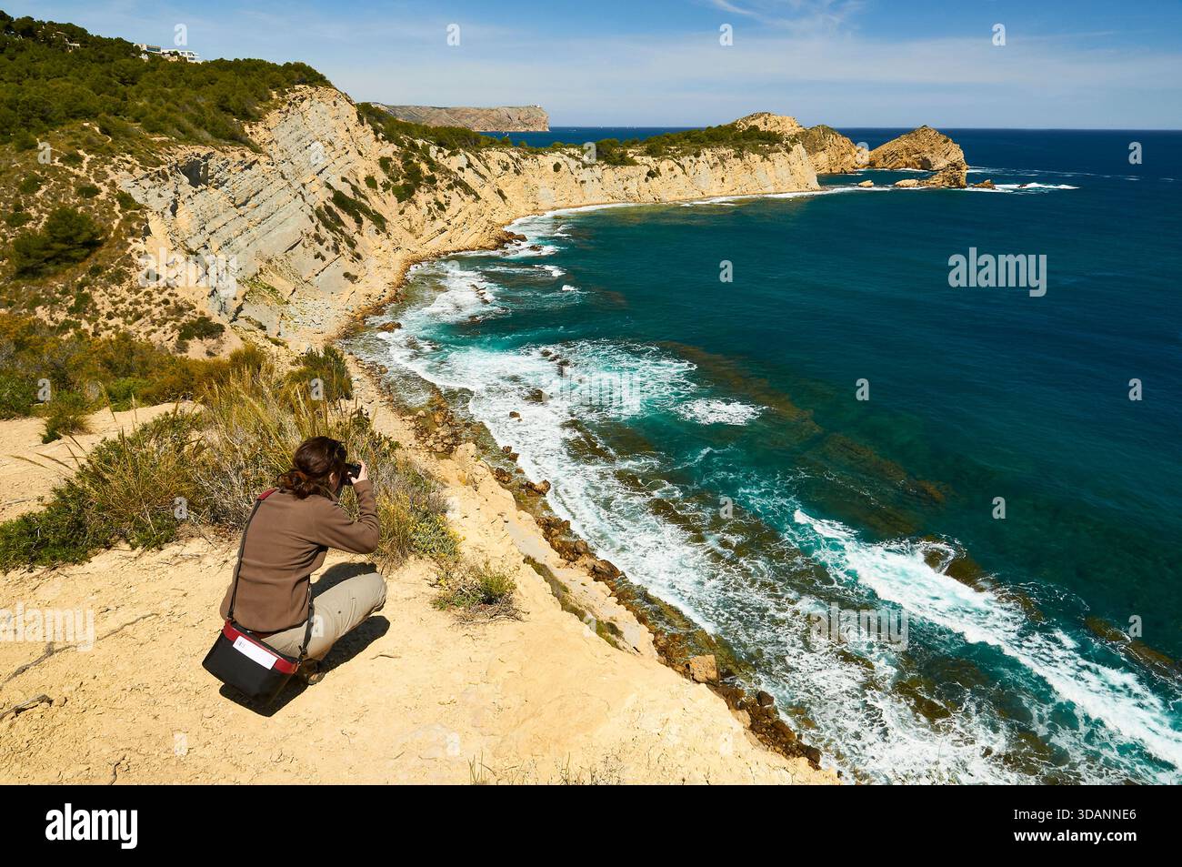 Photographe femme photographiant la plage de Portitxol et le cap Cap Prim depuis le point de vue du Mirador del Portichol (Jávea, Marina Alta, Alicante, Espagne) Banque D'Images