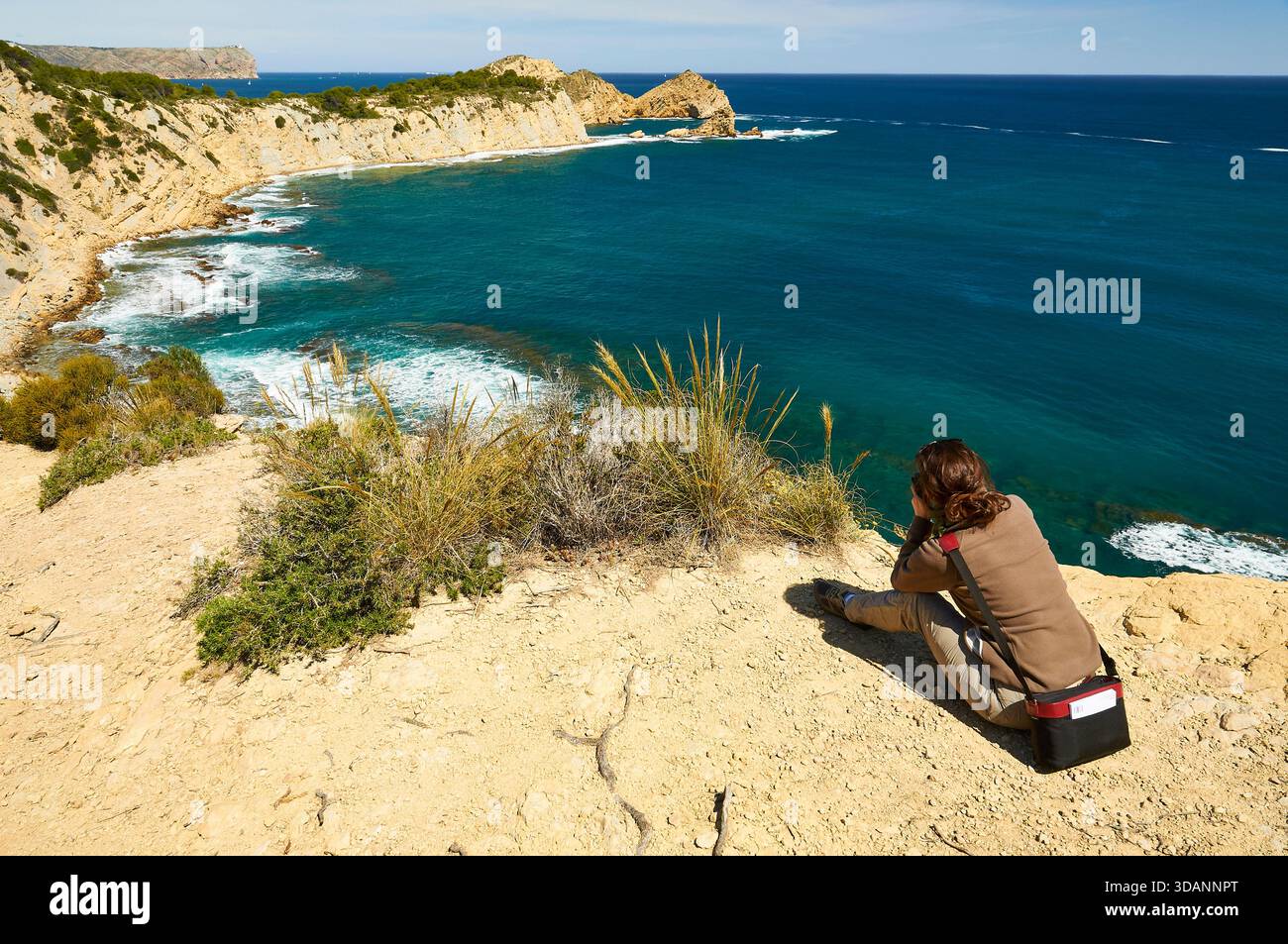 Photographe femme photographiant la plage de Portitxol et le cap Cap Prim depuis le point de vue du Mirador del Portichol (Jávea, Marina Alta, Alicante, Espagne) Banque D'Images