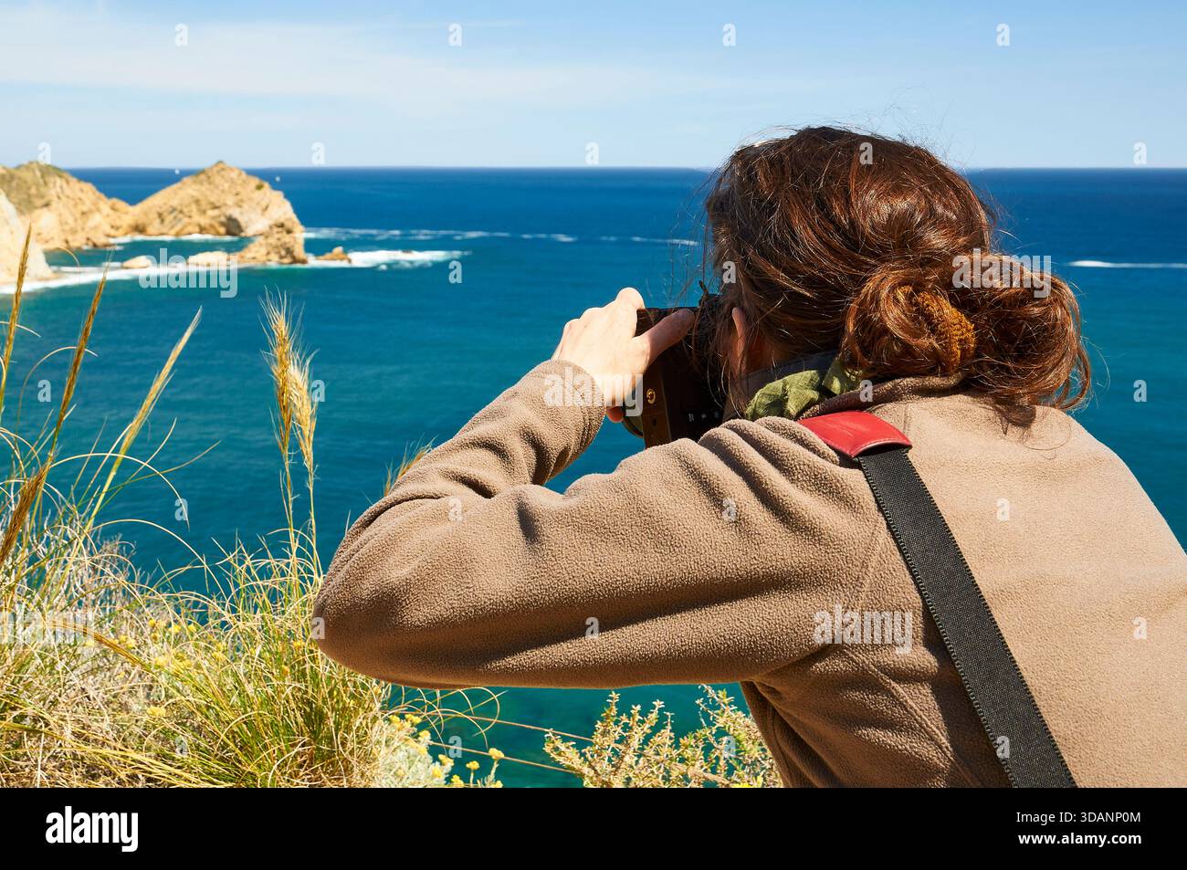 Photographe femme photographiant Cap Prim cape depuis le sentier de randonnée SL-CV 97 par temps clair et ensoleillé (Portichol, Jávea, Marina Alta, Alicante, Espagne) Banque D'Images