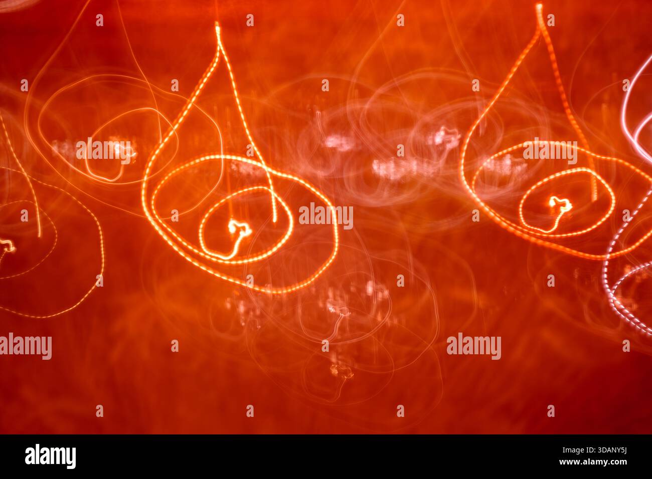 Peinture abstraite de lumière rouge avec mouvement circulaire. Des boucles de néon créatives et des griffonnages de fond pour la conception de fête ou de musique. Banque D'Images