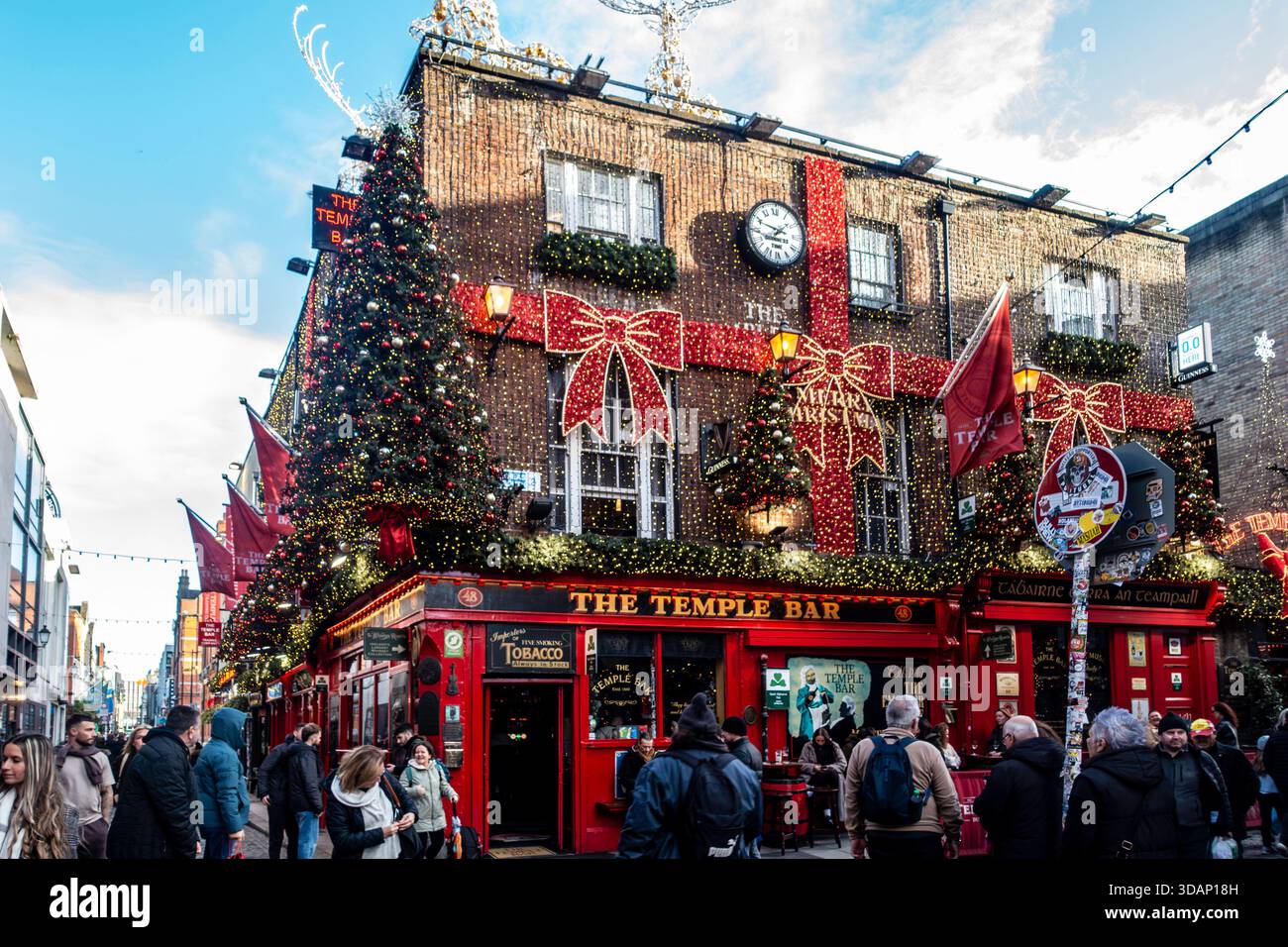 Le pub historique Temple Bar à Dublin, en Irlande, est décoré de couleurs vives avec de nombreux arbres de Noël, des lumières et des noeuds en ruban rouge sur sa façade. Banque D'Images
