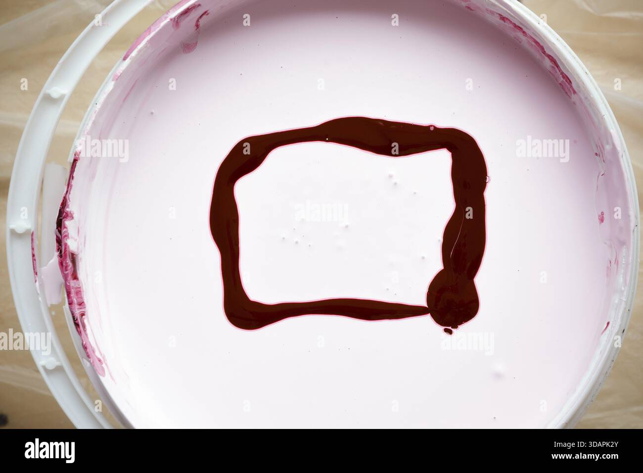 Seau avec peinture blanche avec cadre de couleur rouge Banque D'Images