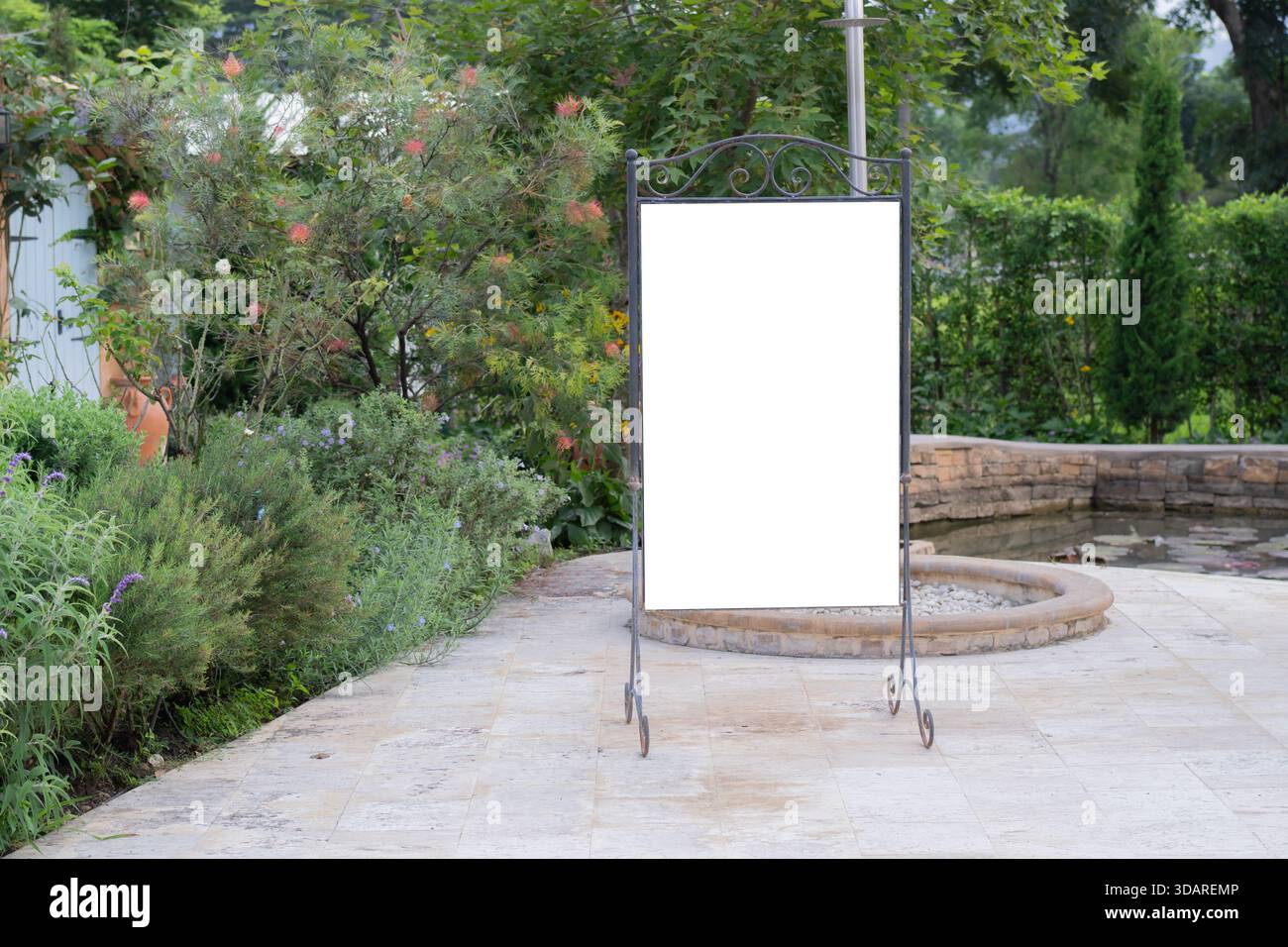 Un panneau d'affichage blanc et blanc sur un stand, isolé sur un fond de jardin vert. La texture de fond d'un signe de maquette vierge offre de l'espace pour customizab Banque D'Images