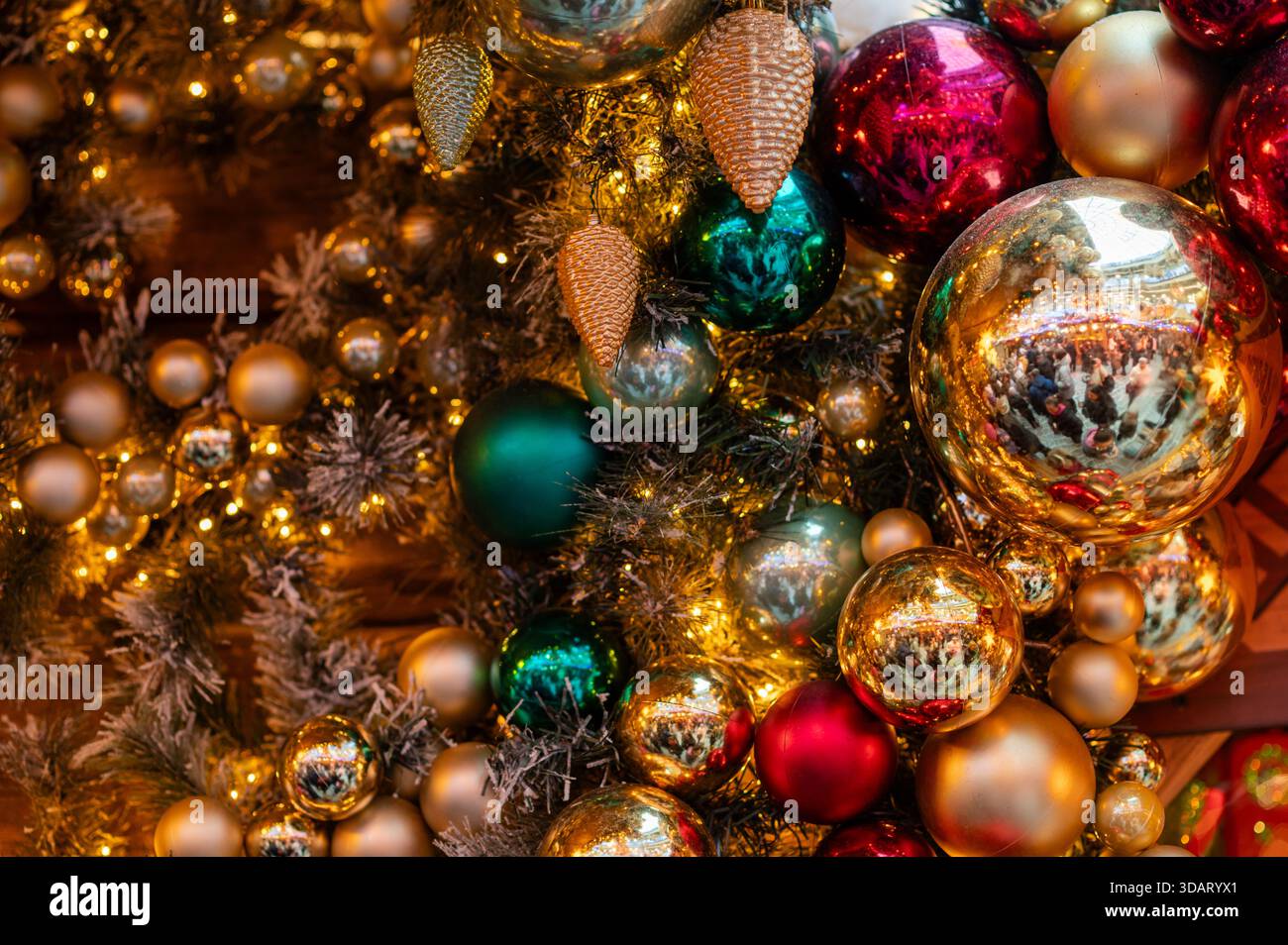 Des boules de Noël multicolores éclatantes scintillent sur un sapin de Noël décoré, créant une atmosphère hivernale lumineuse et joyeuse remplie de lumières chaudes et Banque D'Images