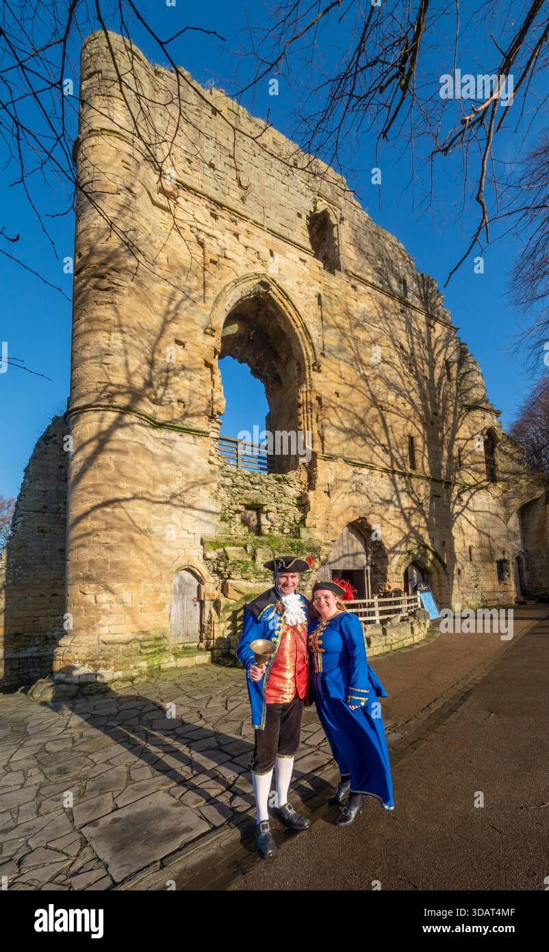 Le crier et consort de Knaresborough dans une livrée bleue traditionnelle debout devant les ruines du château. Banque D'Images