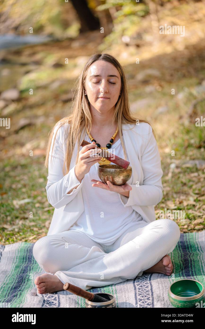 Femme méditant avec bol chantant pour la guérison sonore Banque D'Images
