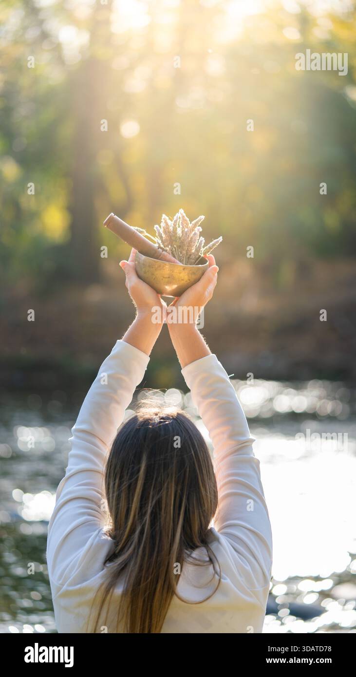Femme tenant le rituel de bol chantant dans la nature Banque D'Images