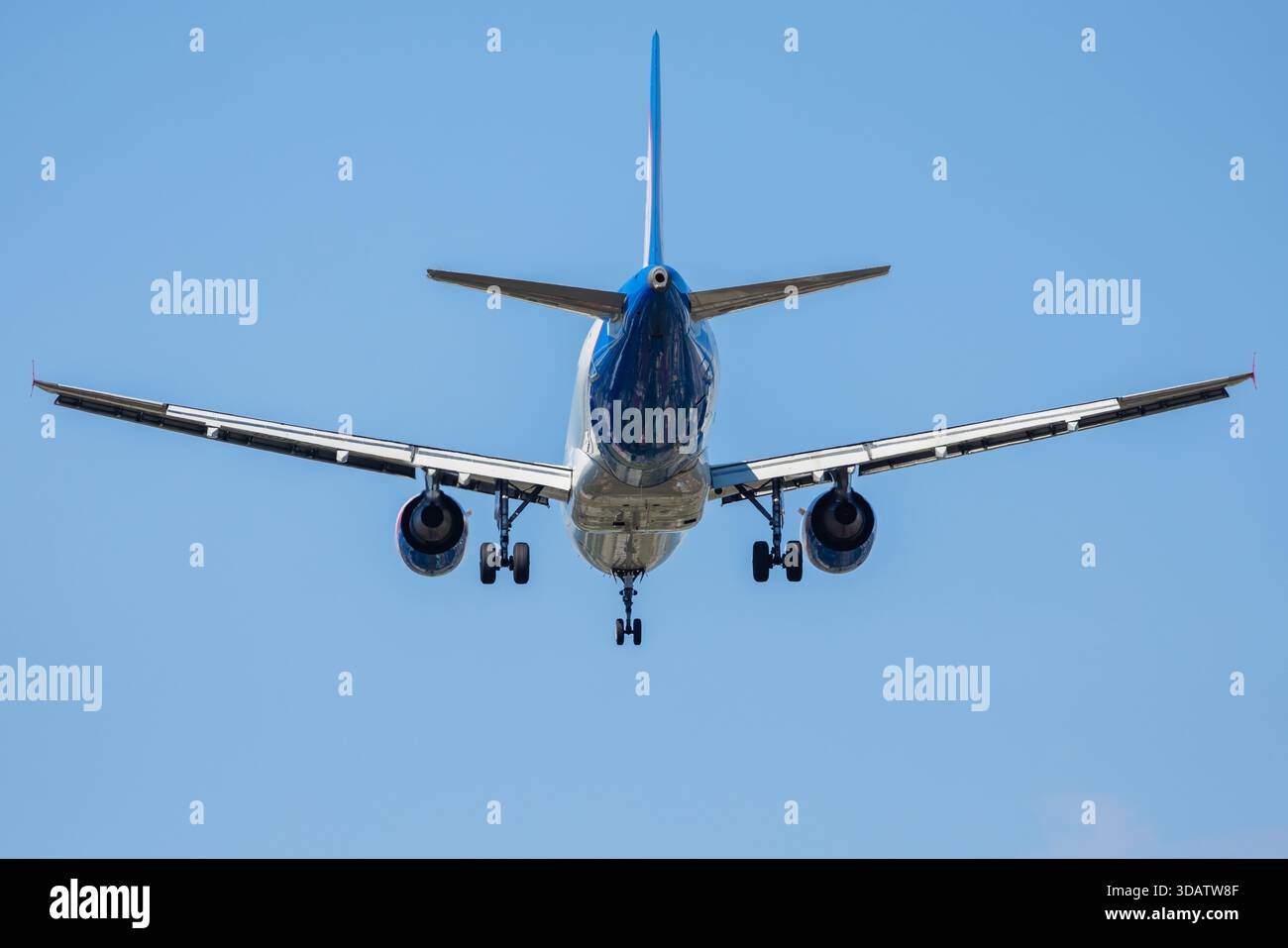 Avion de passagers atterrissant avec train d'atterrissage, vue rapprochée dans le ciel bleu Banque D'Images