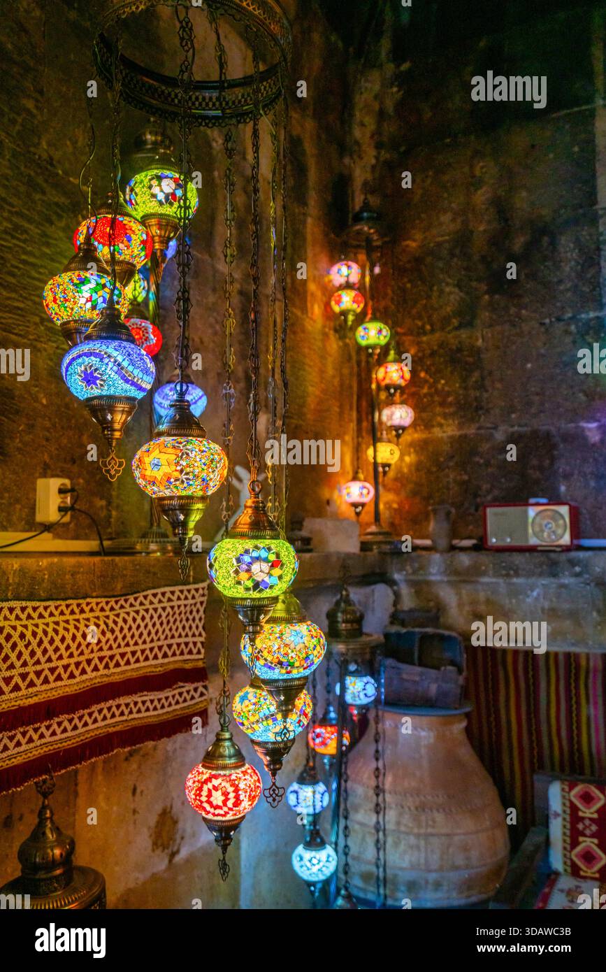 Un affichage captivant de lampes colorées en mosaïque turque illumine un intérieur rustique en Cappadoce, Turquie, créant un cadre chaleureux, accueillant et culturellement Banque D'Images