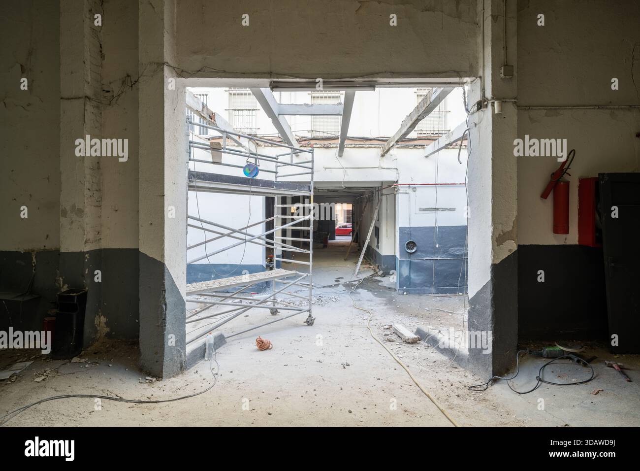 Zone industrielle en cours de rénovation, avec échafaudages apparents et matériaux de construction dispersés. Le site montre des progres visibles Banque D'Images
