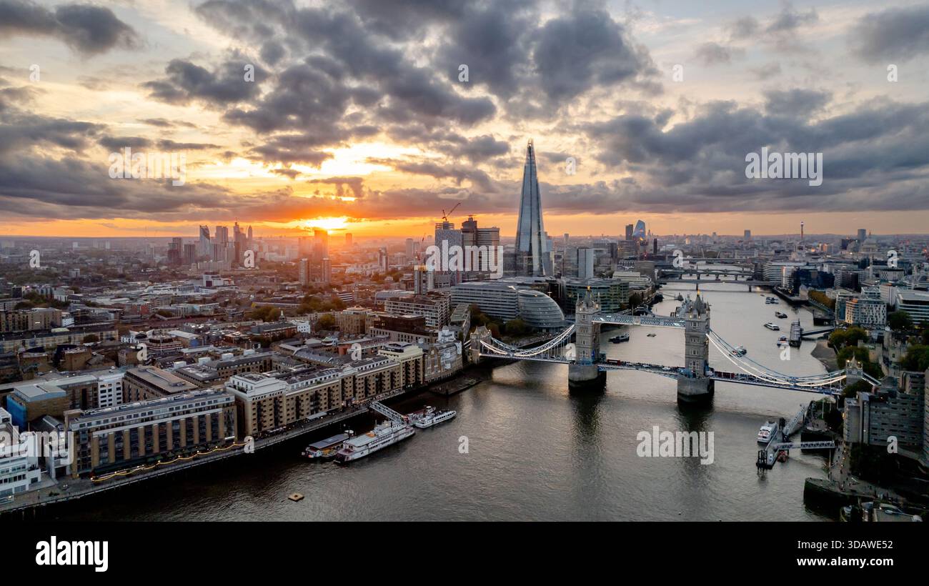 Une vue aérienne époustouflante de Tower Bridge avec l'emblématique Shard en arrière-plan lors d'un coucher de soleil vibrant sur Londres. Le paysage urbain présente un arc moderne Banque D'Images