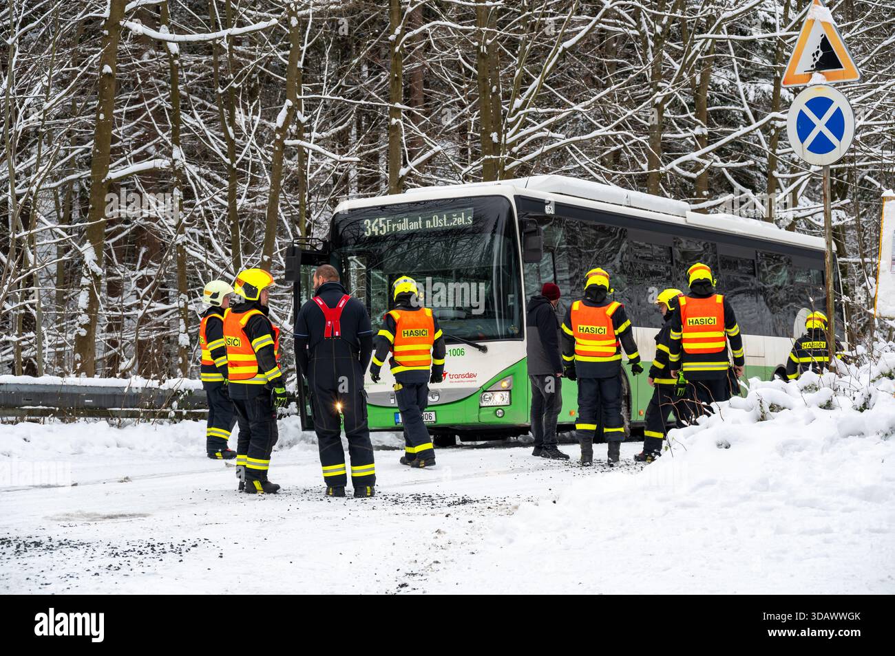 Ostrava, République tchèque - 23.11.2024, des pompiers travaillant pour libérer un bus coincé dans de profondes déneigements sur une route glacée et enneigée, capturant l'hiver c Banque D'Images