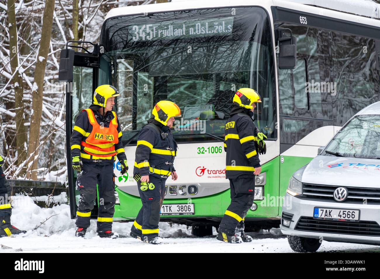 Ostrava, République tchèque - 23.11.2024, des pompiers travaillant pour libérer un bus coincé dans de profondes déneigements sur une route glacée et enneigée, capturant l'hiver c Banque D'Images