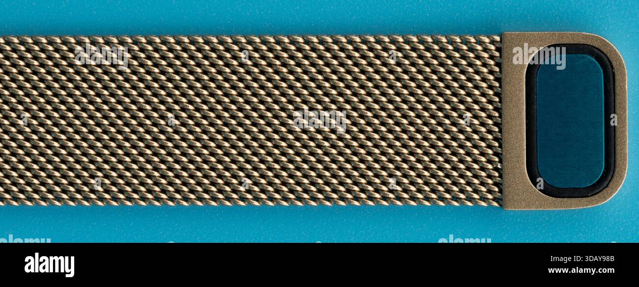 Sangle pour un appareil portable repose sur un fond bleu lisse. La sangle affiche un look métallique et un fermoir sécurisé. Banque D'Images