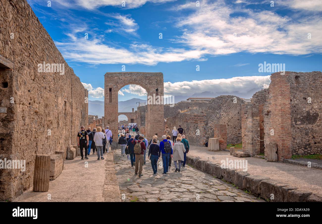 Pompéi, Italie - octobre 26 2025 : les gens marchent entre les bâtiments détruits dans le parc archéologique de Pompéi. Banque D'Images