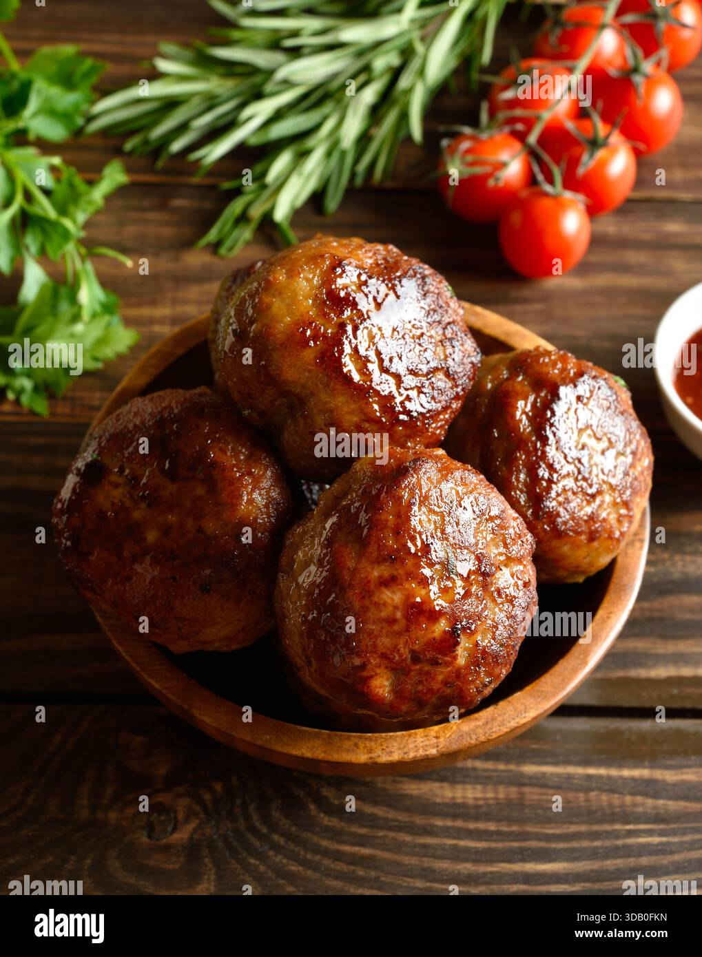 Côtelettes maison savoureuses de viande hachée dans un bol sur fond en bois. Vue rapprochée Banque D'Images
