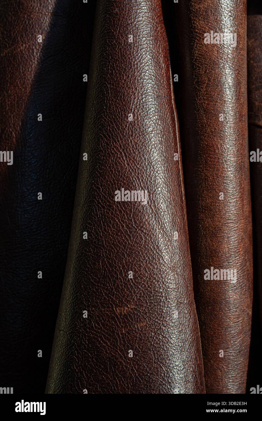 Photographie macro intime mettant en valeur la texture exquise et le motif de grain du cuir marron haut de gamme. Plis multiples et couches de cuir Banque D'Images